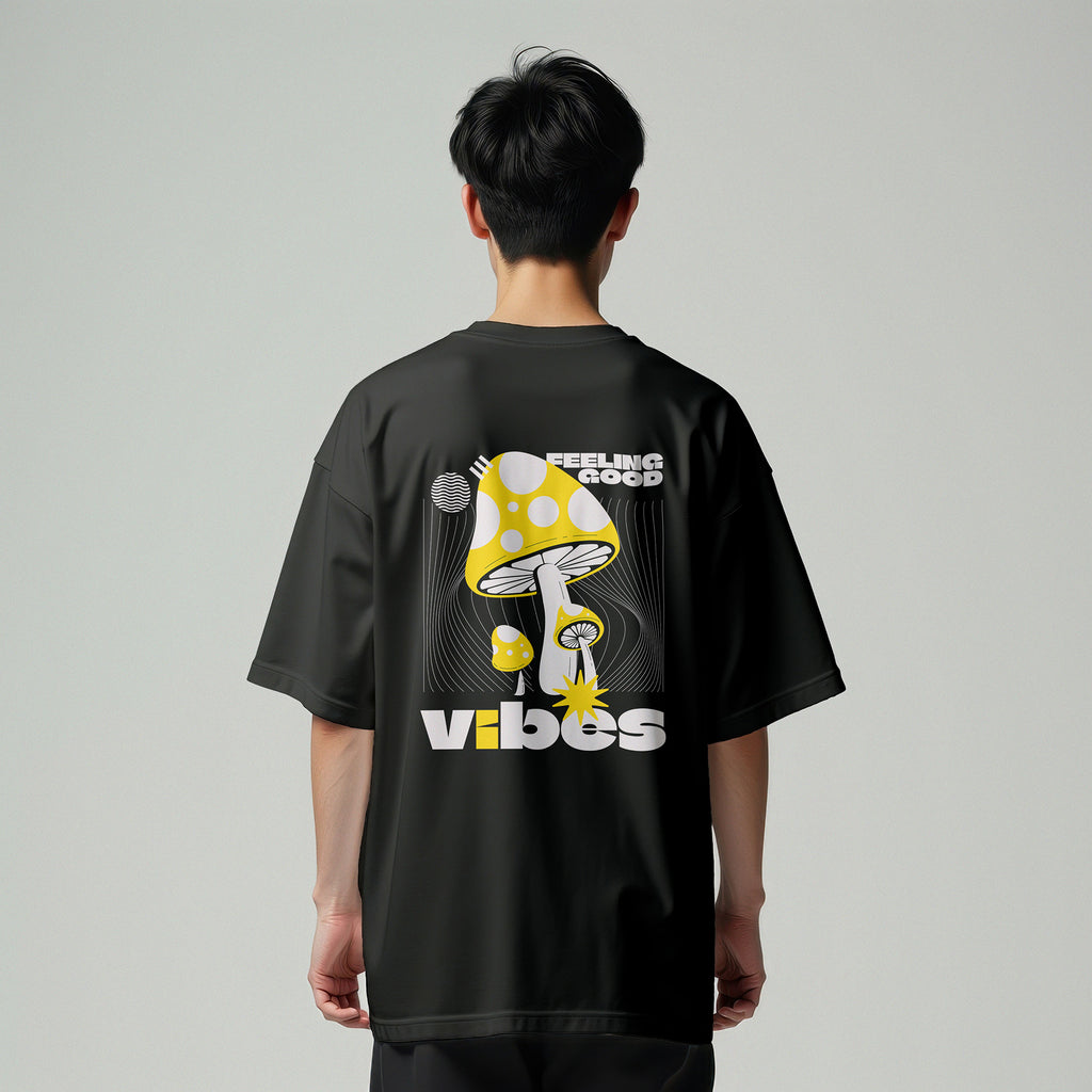 Person wearing a black t-shirt with a mushroom graphic and text on the back against a gray background